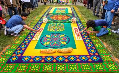 Decoran sus calles con alfombras de aserrín multicolor