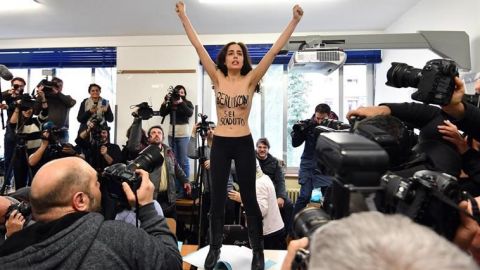 Una activista de Femen sin camiseta interrumpe a Berlusconi en su votación