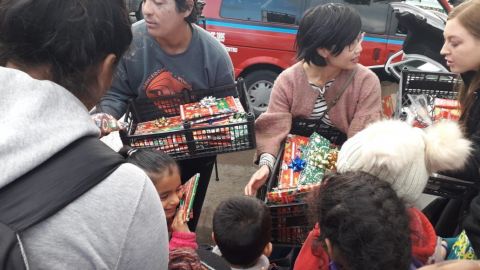 Voluntarios entregan regalos a niños migrantes