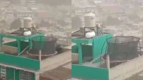 VIDEO: Hombre sostiene su tinaco en la azotea para que el viento no se lo lleve