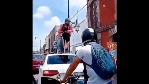 Ciclista pasa por encima de automóvil que obstruía ciclovía en Querétaro