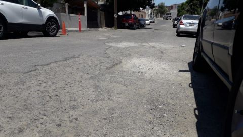 Vecinos reportan daños en sus carros por calle convertida en cráter