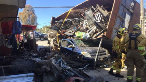 Vehículo pesado cae sobre carro y deja a una persona atrapada; hay heridos