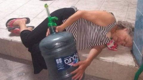 Mujer de la tercera edad duerme en la calle esperando llenar su garrafón